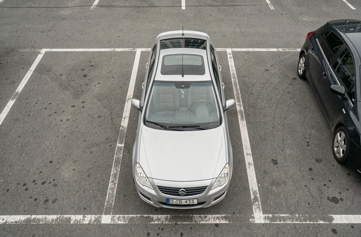 Vue aérienne d'une voiture garée dans une place de parking avec très peu d'espace sur les côtés