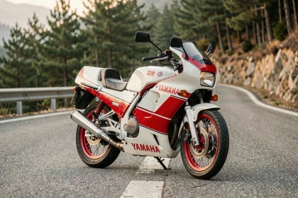 Yamaha TZR 125 sportive deux temps garée sur une route de montagne sinueuse entourée de forêt de pins